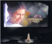  ?? PHOTO: CHRIS PIZZELLO/INVISION/AP ?? An image of the late Carrie Fisher is displayed as Sara Bareilles performs during the In Memoriam tribute