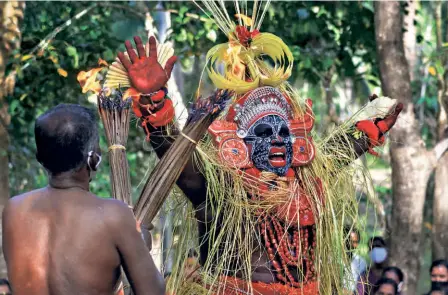  ?? ?? THE THEYYAM gets in the mood at Paalankall­u Gulikan Kaavu in Kerala’s Kasaragod.