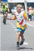  ??  ?? PROUD: Junior athlete Chris Fry runs along Sheridan St.