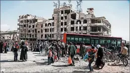  ?? ABDULMONAM EASSA/GETTY-AFP ?? Syrian civilians approach a bus Sunday as they prepare to evacuate the town of Arbin.