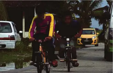  ?? PIC BY HAIRUL ANUAR RAHIM ?? Mohd
Bihamdi Mohamed, 16, and Mohd Nor Hakmairwan Hussen, 17, riding their modified bicycles at Taman Sinaran Kempas,
Johor Baru.