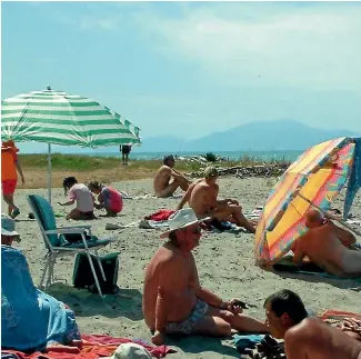  ??  ?? A mix of bathers on the beach at Mapua make the most of the camps limited ‘‘clothes optional’’ policy.