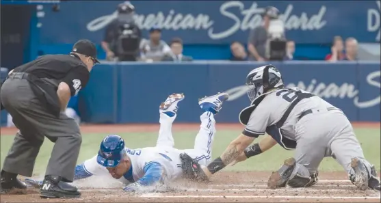  ?? The Canadian Press ?? Toronto Blue Jays’ Ezequiel Carrera scores ahead of the tag by New York Yankees catcher Gary Sanchez during second-inning AL action in Toronto on Thursday. The Jays won 4-0.