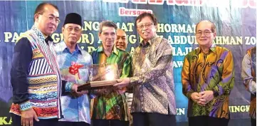  ??  ?? (From left) Mulok, Piee and Penghulu Goh Leng Tong present a gift to Abang Johari (second right) during the dinner, witnessed by Uggah.