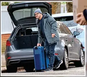  ?? ?? Casual: Firth arrives with suitcase at his former residence