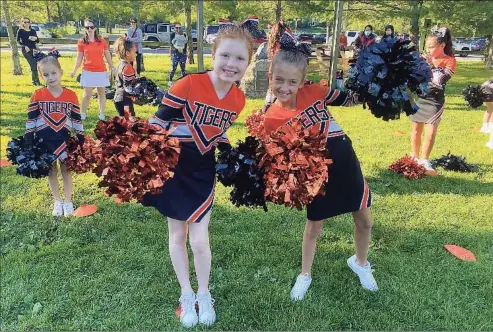  ?? Kelsey Rollinson / Contribute­d photo ?? Ridgefield Tigers team members Paget Rollinson, left, and Avery Dobiejko flash their pom-poms. The squad recently came home with first-place trophies from local and state competitio­ns.