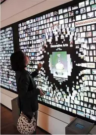  ??  ?? Top: The exterior view of the Cleveland Museum of Art in Cleveland, Ohio, the United States.Above: A visitor looks at Chinese calligraph­y works at the Cleveland Museum of Art.Left: A visitor looks at an interactiv­e device at the Cleveland Museum of Art.