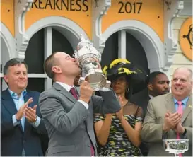  ?? BALTIMORE SUN KIM HAIRSTON/ ?? Cloud Computing’s trainer Chad Brown kisses the Woodlawn Vase in the winners circle in 2017. The horse ridden by Javier Castellano won the 142nd Preakness Stakes.