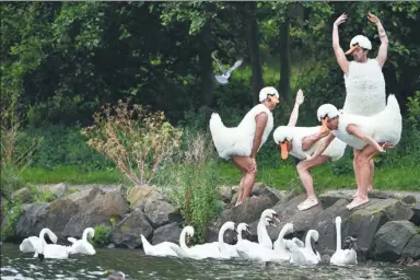  ?? JEFF J MITCHELL / GETTY IMAGES ?? Dancers from Tutu, an all-male ballet troupe — wearing spoof Swan Lake costumes — perform at St Margaret’s Loch in Edinburgh, Scotland.