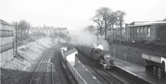  ?? W S Sellar ?? It took the Caledonian Railway the best part of 15 years to evolve the goods-only Leith Western Docks line to also carry passengers, doubtless because there was need for a new section of railway east from Newhaven – a new junction, Newhaven Junction, was created just west of a new station site. This 11 February 1961 scene at Newhaven, looking east from Craighall Road, shows the station, the original formation on the left and the 1879 passenger route in use by a Leith to Edinburgh (Princes Street) passenger train, with passengers waiting, and a Leith-bound train is ‘pegged’ too. Although there had been periods where CR ‘Passenger Tanks’ were the dominant power, by 1961 the steam provided was as likely to be a Fairburn 2-6-4 tank as anything else, No 42271 on this occasion, but nominally it was a diesel-worked route and had been since sometime in 1958.