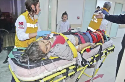  ??  ?? ADANA: This picture obtained from the Ihlas News Agency shows an injured girl taken to hospital following a fire at a school. — AFP