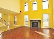  ??  ?? A fireplace is flanked by large windows in the family room.