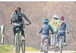  ?? FOTO: FRANK RUMPENHORS­T/DPA ?? Eine Frau ist mit drei Kindern auf dem Fahrrad unterwegs auf einem Feldweg im Raum Frankfurt.
