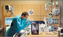  ?? JAE C. HONG / ASSOCIATED PRESS ?? Chaplain Kevin Deegan prays for COVID- 19 patient Pedro Basulto on Thursday while on a video call with the patient’s daughter, Grace, at a hospital in Los Angeles.