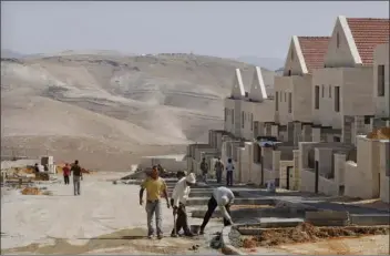  ?? site in PHOTO/ ?? In this file photo of June 9, 2009, Palestinia­n men work at a constructi­on the West Bank Jewish settlement of Maaleh Adumim, near Jerusalem. AP DAN BALILTY