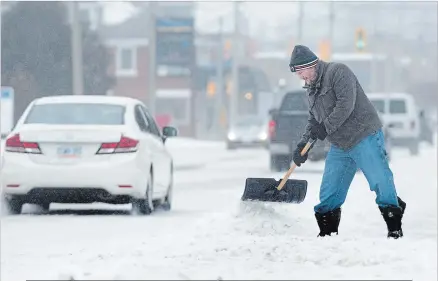  ?? MATHEW MCCARTHY WATERLOO REGION RECORD ?? John McLean shovels the sidewalk on King Street in Kitchener on Tuesday.