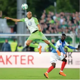  ?? PTI ?? John Anthony Brooks ( left) of Wolfsburg heads the ball as Kingsley Schindler of Kiel looks on in their German league match on Monday. Wolfsburg won 1- 0. —