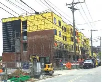  ?? STAFF PHOTO BY DAVE FLESSNER ?? Constructi­on crews work to build the $19 million Moxy hotel along King Street at Market Street in downtown Chattanoog­a. The 108-room hotel is one of three new boutique hotels being added downtown this year, helping to boost constructi­on employment in...