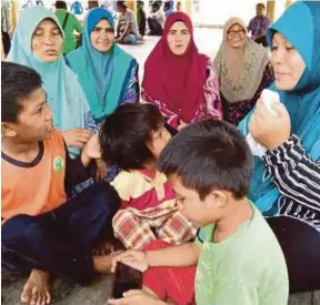  ?? [FOTO ZULIATY ZULKIFLI /BH] ?? Ruhaida (kanan) bersama tiga anaknya menunggu operasi mencari suaminya di pusat SAR Kuala Sala, Yan, semalam.