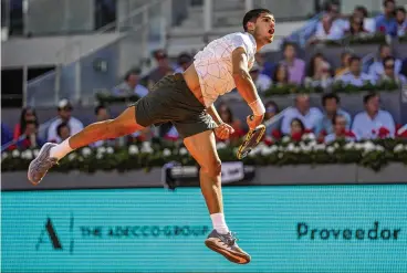  ?? BERNAT ARMANGUE / ASSOCIATED PRESS ?? Spain’s Carlos Alcaraz serves Friday en route to defeating Rafael Nadal, his countryman and idol, in the quarterfin­al round of the Madrid Open.