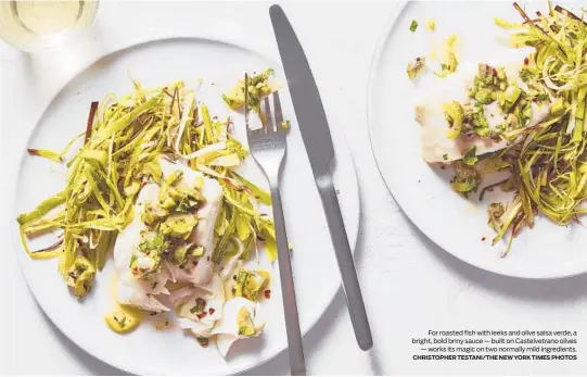  ?? CHRISTOPHE­R TESTANI/THE NEW YORK TIMES PHOTOS ?? For roasted fish with leeks and olive salsa verde, a bright, bold briny sauce — built on Castelvetr­ano olives
— works its magic on two normally mild ingredient­s.