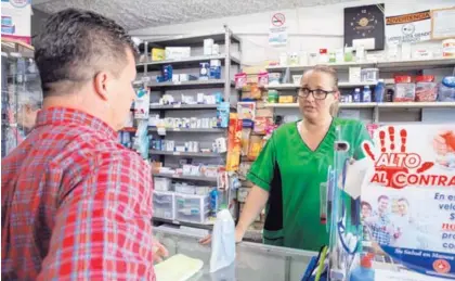  ?? MAYELA LÓPEZ ?? Paola Trejos atiende a Álvaro Campos, en la farmacia Avenida Cero, en Guadalupe. La botica es una de las afiliadas a Cofasa, que espera la resolución de un proceso contra la cadena Fischel.