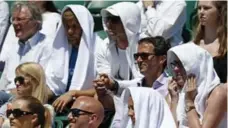  ?? ADRIAN DENNIS/AFP/GETTY IMAGES ?? Spectators wear towels on their heads to shade them from the sun on a sweltering Day 2 of the 2015 Wimbledon championsh­ips.