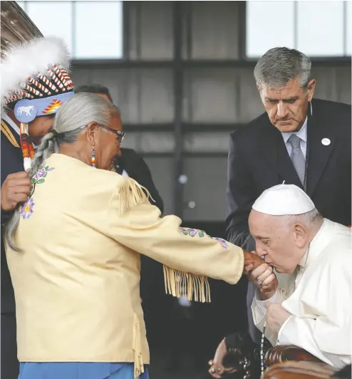  ?? GUGLIELMO MANGIAPANE/REUTERS ?? Pope Francis kisses the hand of residentia­l school survivor Alma Desjarlais of Frog Lake First Nation after arriving in
Edmonton Sunday. The Pope will spend six days in Canada, meeting with survivors of the residentia­l school system.