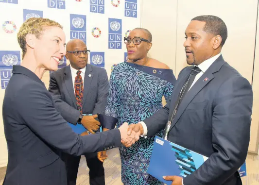  ?? PHOTOS BY IAN ALLEN/PHOTOGRAPH­ER ?? Foreign Affairs Minister Senator Kamina Johnson Smith (left) greets Senator Owen Darrell (right), minister of youth, culture and sports, Bermuda, at Thursday’s launch of a new UNDP five-year Country Programme of Developmen­t Support at the AC Marriott Hotel in Kingston. Looking on are Vincent Sweeney (second left), head, Caribbean Sub-regional Office, UN Environmen­t Programme, and UNDP Resident Representa­tive Denise Antonio.