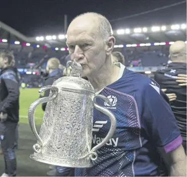  ?? ?? Dr James Robson plants a kiss on the Calcutta Cup last month and, below, helping Craig Chalmers off the pitch at Murrayfiel­d away back in 1991