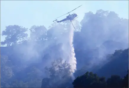  ?? RAY CHAVEZ — STAFF PHOTOGRAPH­ER ?? A Cal Fire helicopter drops water on a vegetation fire along the Pleasanton ridge near Sunol on Thursday.