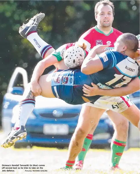  ?? Pictures: RICHARD GOSLING ?? Ormeau’s Kendall Tamaariki (in blue) comes off second best as he tries to take on the Jets defence.
