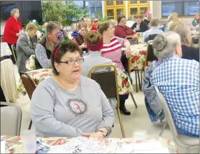  ?? Westside Eagle Observer/SUSAN HOLLAND ?? Guests at the Billy V. Hall Senior Activity and Wellness Center Christmas dinner join in singing Christmas carols while waiting for lunch to be served Thursday, Dec. 20. Over 50 guests were served at lunch with a menu featuring glazed ham, casseroles, Waldorf salad, rolls and coconut cream dessert.