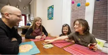  ?? CARLOS OSORIO/TORONTO STAR ?? A weekend competitio­n is underway as Philip, left, and Cynamin Vettese play Uno with their kids Emerson, 7, and Maxwell, 9. The family enjoyed taking part in filming The Great Wild Indoors.