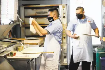  ?? Photos by Scott Strazzante / The Chronicle ?? Luis Quintero and Irvin Tamaal work in the kitchen at Gialina Pizzeria in San Francisco. The restaurant’s backofhous­e staff, like cooks and dishwasher­s, all make above minimum wage.