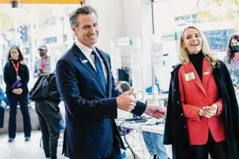  ?? Andri Tambunan/Special to The Chronicle ?? Gov. Gavin Newsom and his wife, Jennifer Siebel Newsom, prepare to address reporters after casting their votes at the California Museum in Sacramento on Tuesday.