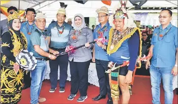  ??  ?? Ajang presents the ‘sengayuh’ to Sharifah Hasidah after the opening ceremony of Belaga Regatta.