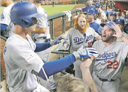  ?? Wally Skalij Los Angeles Times ?? CODY BELLINGER IS GREETED by Clayton Kershaw (22), Justin Turner (10) and others in the dugout after his solo home run gave the Dodgers a 2-0 lead in the fifth inning of Game 3. Bellinger said he had been pressing in the series before that at-bat.