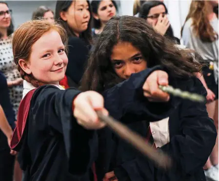  ??  ?? Harry Potter fans posing with their authentic wands (well, they probably can’t really cast a spell!) at an anniversar­y presentati­on at Waterstone­s bookshop in London on Monday. — Reuters