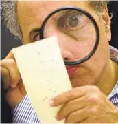  ?? ALAN DIAZ AP ?? Broward County, Fla., canvassing board member Robert Rosenberg examines a ballot in Nov. 2000.
