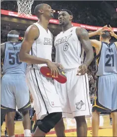  ?? DAVID SANTIAGO/ASSOCIATED PRESS ?? Miami’s LeBron James (right, with teammate Chris Bosh), despite shooting 4 for 14, finished with 18 points, 10 assists and eight rebounds to help snap Memphis’ eightgame winning streak Friday night.