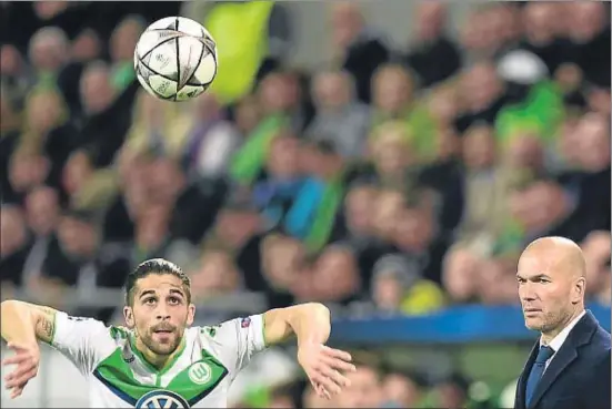  ?? JOHN MACDOUGALL / AFP ?? Zinédine Zidane mirant el lateral suís Ricardo Rodríguez mentre serveix de banda durant el partit de dimecres a Wolfsburg