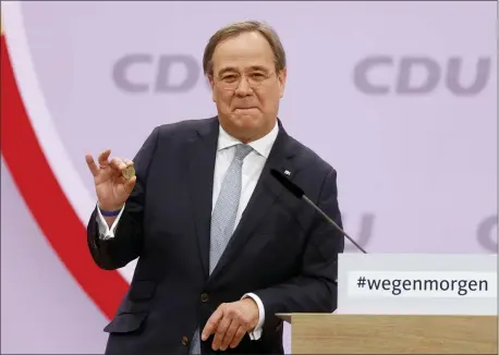  ?? ODD ANDERSEN — POOL VIA AP ?? North Rhine-Westphalia’s Governor and candidate as leader of the Christian Democratic Union (CDU) Armin Laschet shows a luck coin offered to him by his father as he delivers his speech on the second day of the party’s 33rd congress held online because of the coronaviru­s pandemic, in Berlin on January 16, 2021. German Chancellor Angela Merkel’s party is choosing a new leader on Saturday, eight months before voters decide who will succeed Merkel in a national election.