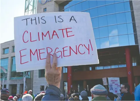  ?? JEAN LEVAC / POSTMEDIA NEWS ?? Residents gather outside Ottawa City Hall last week to show their support for a motion to declare a climate emergency in the nation’s capital. Canada’s emergency climate declaratio­n movement began last year in Quebec, after a summer heat wave claimed the lives of 93 people.