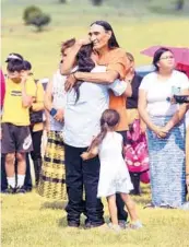  ?? ERIN BORMETT/THE ARGUS LEADER ?? Relatives embrace each other as the remains of nine children are returned home Friday at the Yankton Sioux Reservatio­n in South Dakota.