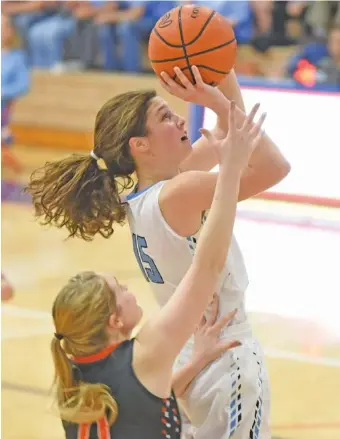  ?? STAFF PHOTO BY TIM BARBER ?? McMinn Central’s Melia Baker eludes Meigs County’s Kaylie Moore as she scores two of her 12 first-half points in the Region 3-AA championsh­ip game Wednesday night at Red Bank. McMinn Central won 52-37.