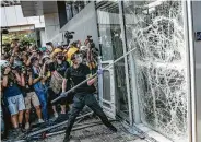  ?? Anthony Kwan / Getty Images ?? Protesters smash glass doors and windows of the Legislativ­e Council Complex.