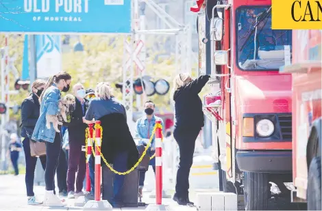  ?? GRAHAM HUGHE/THE CANADIAN PRESS ?? People line up at a food truck in the Old Port in Montreal on Sunday. Quebec's health situation remains relatively stable.