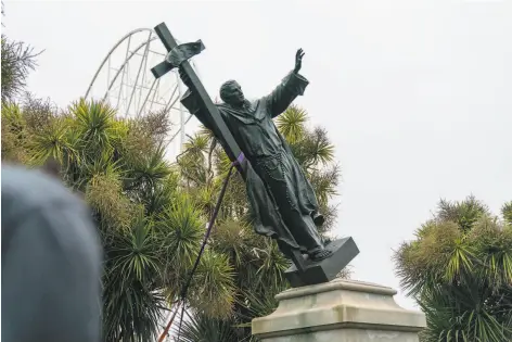  ?? Photos by Jungho Kim / Special to The Chronicle ?? Above: The statue of Junipero Serra is pulled to the ground by protesters in Golden Gate Park. Below: The statue of Francis Scott Key hits the ground after a group of protesters used ropes to pull it down in Golden Gate Park on Friday.