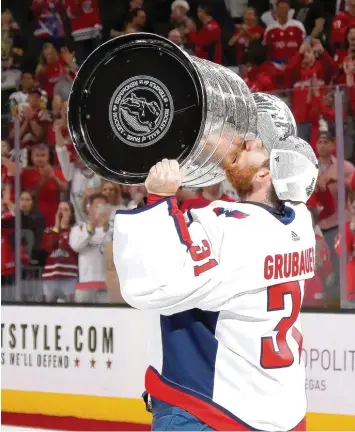  ?? Foto: Bruce Bennett, afp ?? Ein Küsschen in Ehren … Philipp Grubauer hat mit den Washington Capitals die begehrtest­e Trophäe im Eishockey gewonnen: den Stanley Cup.